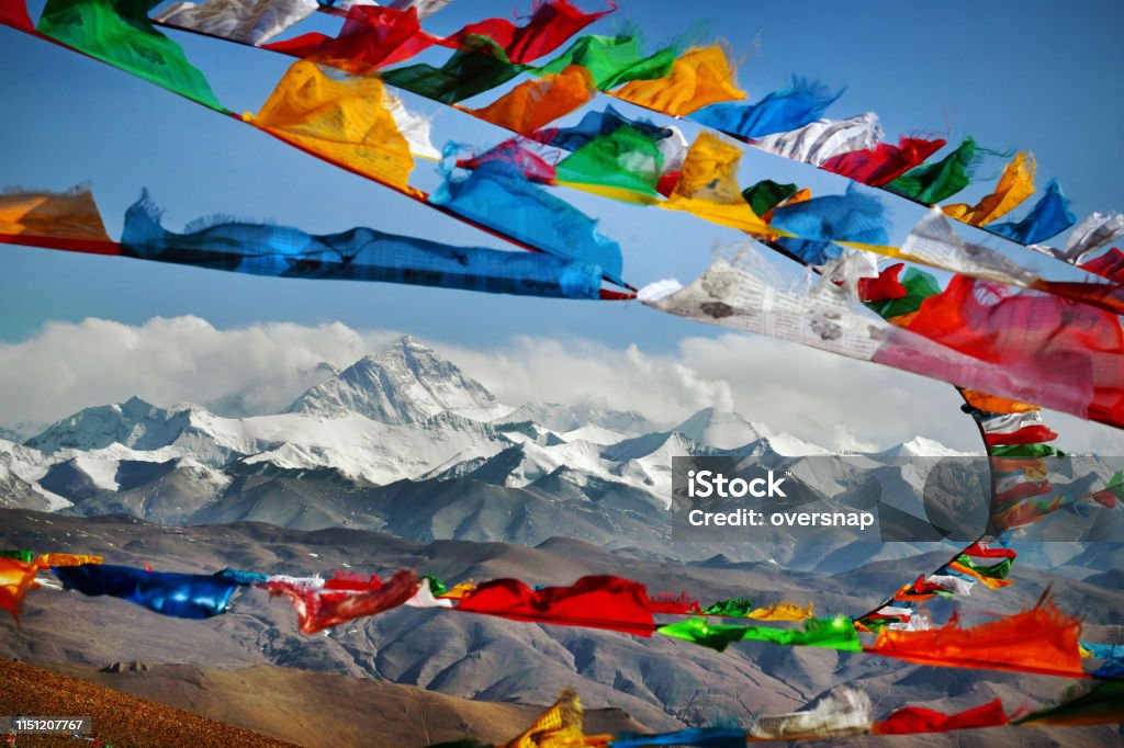 Mount Everest in Himalayas of Tibet viewed at distance through Buddhist prayer flags strewn across a high Himalayan Mountain pass
Everest, known in Nepali as Sagarmatha and in Tibetan as Chomolungma, is Earth's highest mountain above sea level, located in the Mahalangur Himal sub-range of the Himalayas. The international border between Nepal and China runs across its summit point